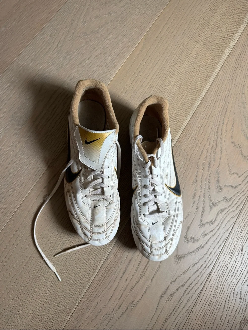 Nike Men’s White Soccer Shoes with Black Swoosh and Gold Highlights